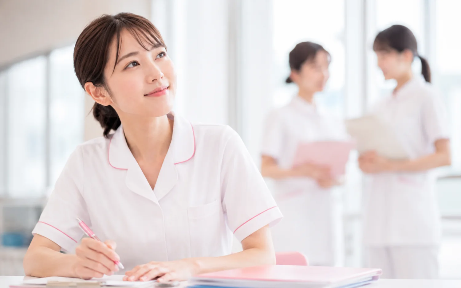 デスクで記録をとる看護師